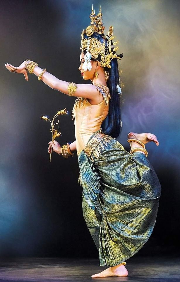 a woman in an elaborate costume is dancing