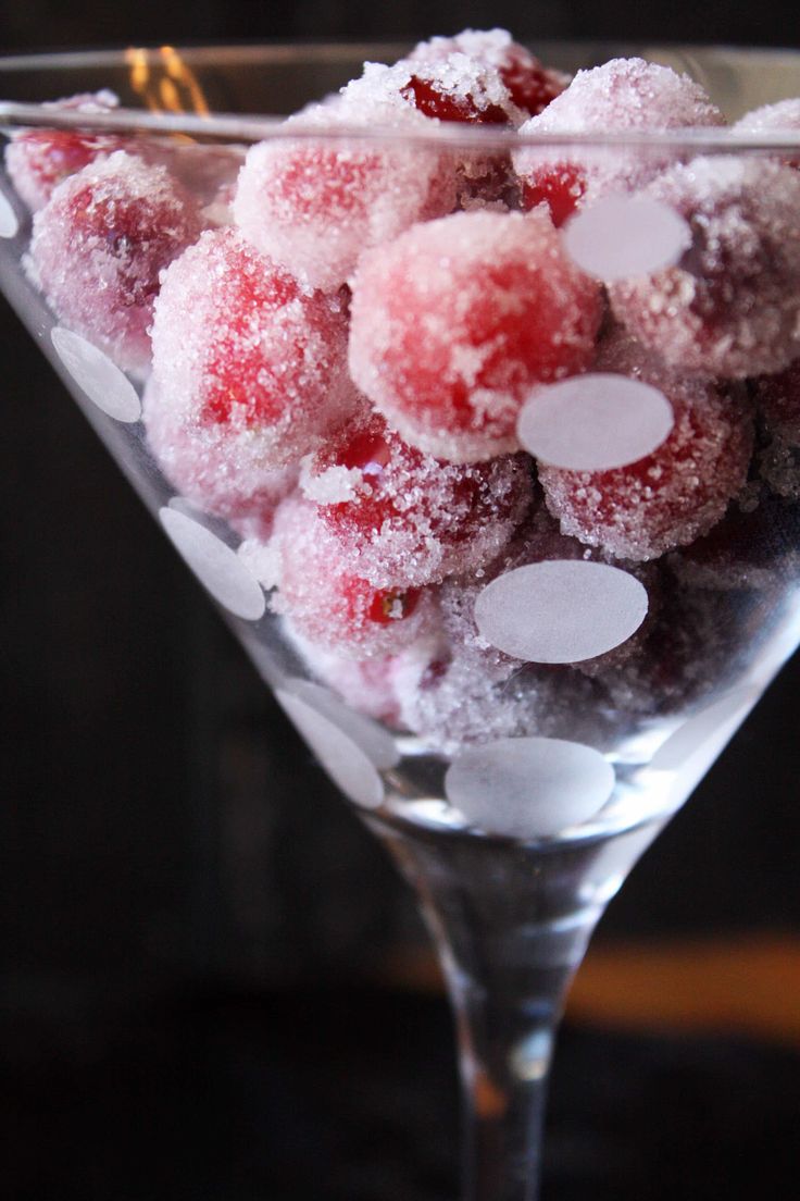 a martini glass filled with sugared cranberries and powdered sugar sprinkles