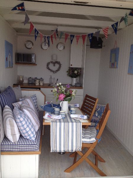 a table and chairs in a small room with blue and white decor on the walls