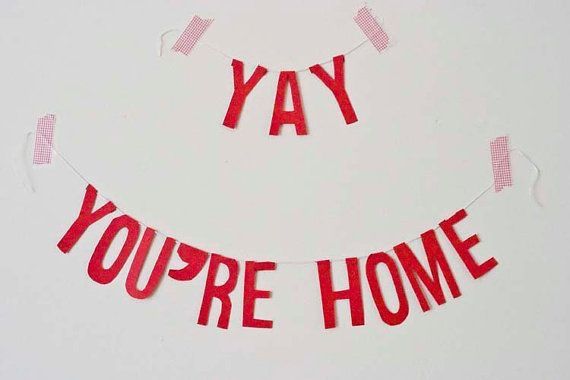 a red banner that says yay you're home hanging on a white wall