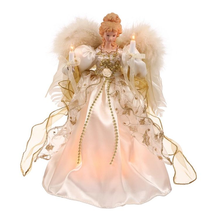 an angel figurine with white and gold feathers on it's head, holding two candles