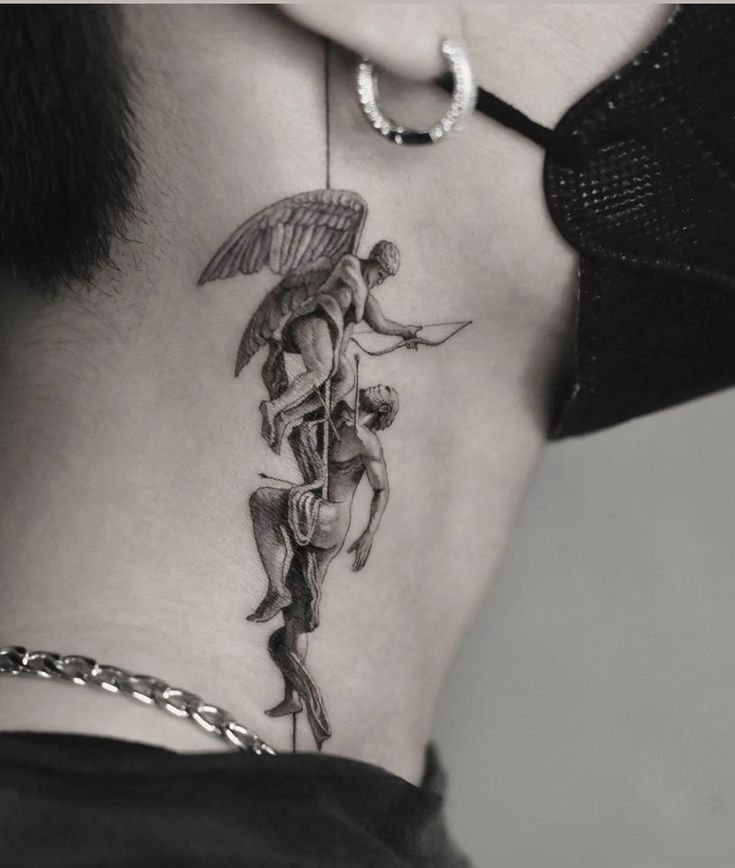 the back of a woman's neck with an angel and devil tattoo on it