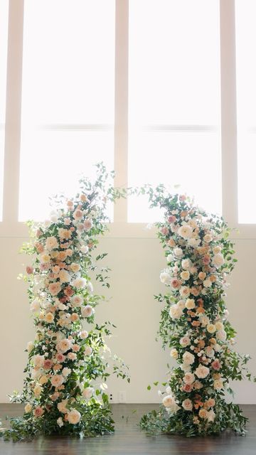 two floral arrangements in front of large windows