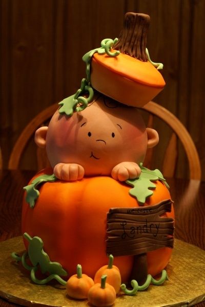 a cake that is shaped like a baby in a pumpkin costume