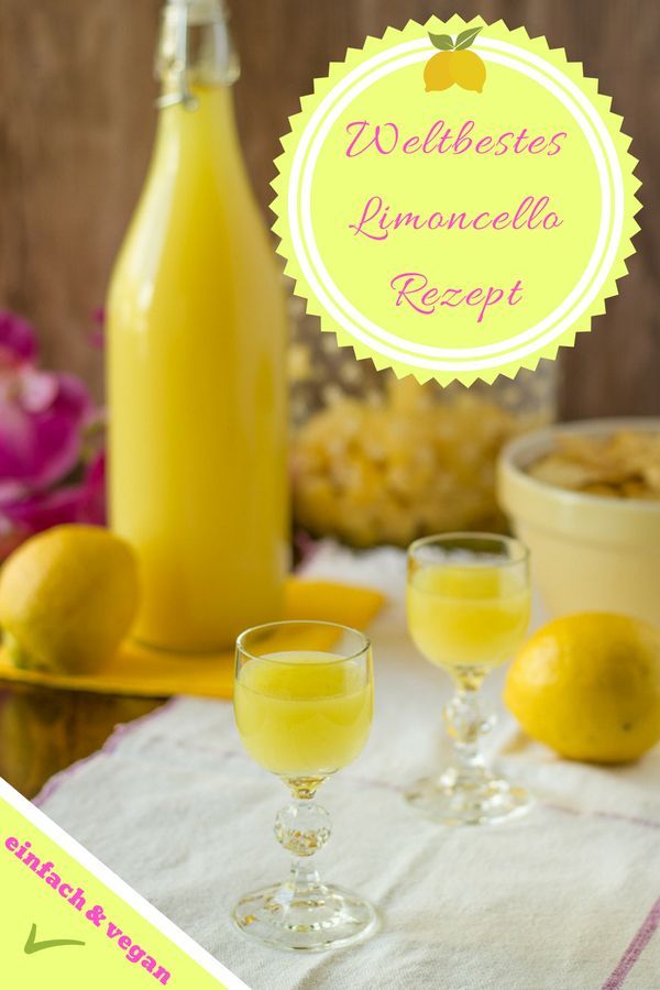 two glasses filled with lemonade sitting on top of a table next to a bottle