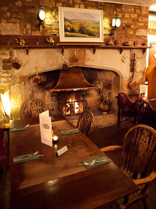 a table and chairs in front of a fire place