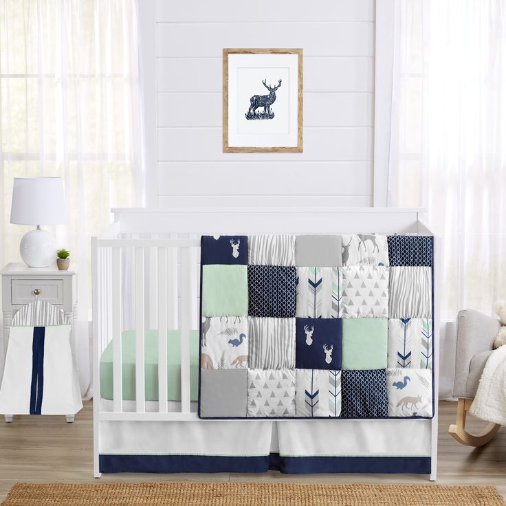 a baby crib bedding set with blue and green accents