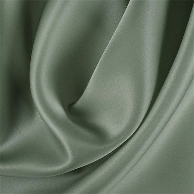 a close up view of a green satin fabric with very soft folds and smooth lines