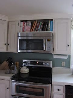 a kitchen with white cabinets and stainless steel appliances, including a microwave above the stove