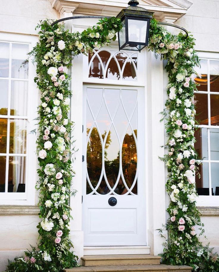 the instagram page shows an image of a white door with flowers and greenery on it