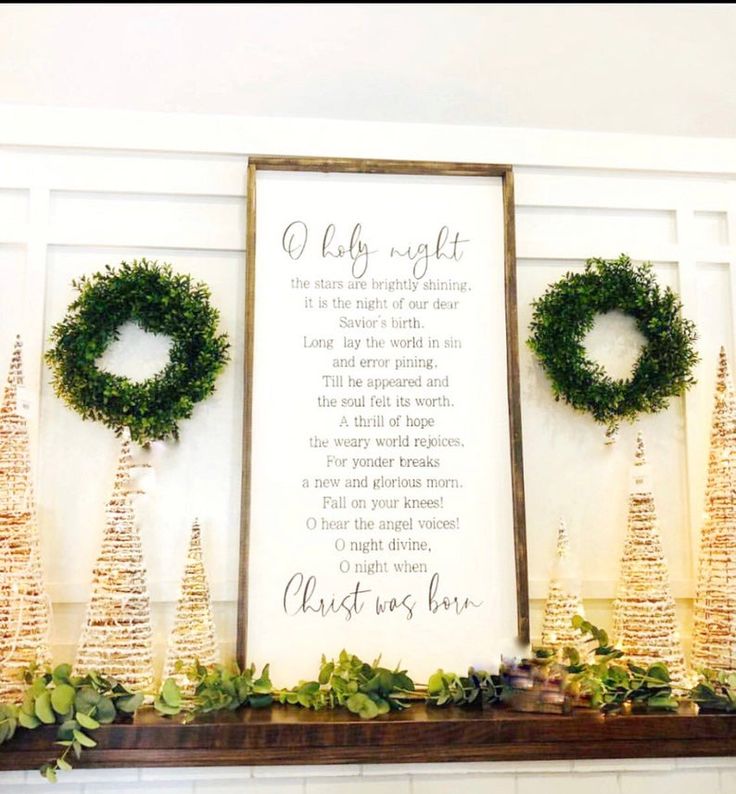 a fireplace mantle decorated with christmas wreaths and greenery