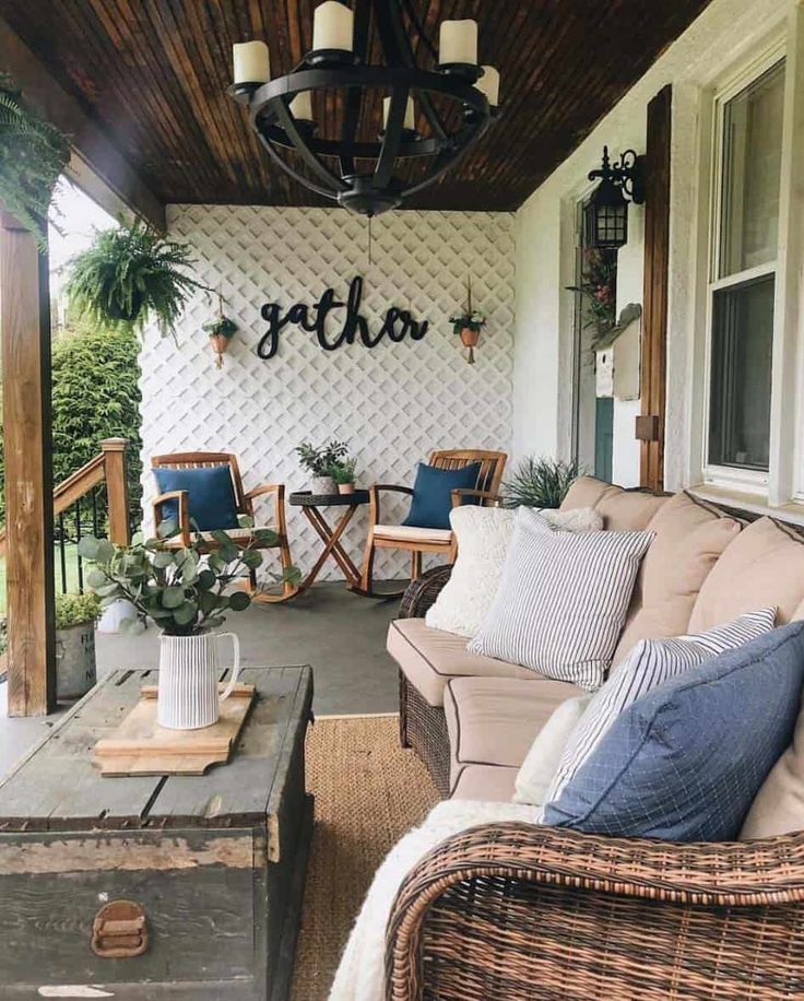 a porch with wicker furniture and plants on the front porch, which is decorated in blue and white