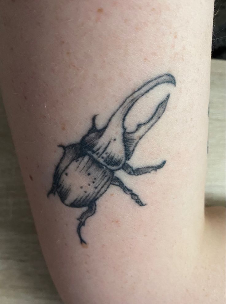 a small beetle tattoo on the leg