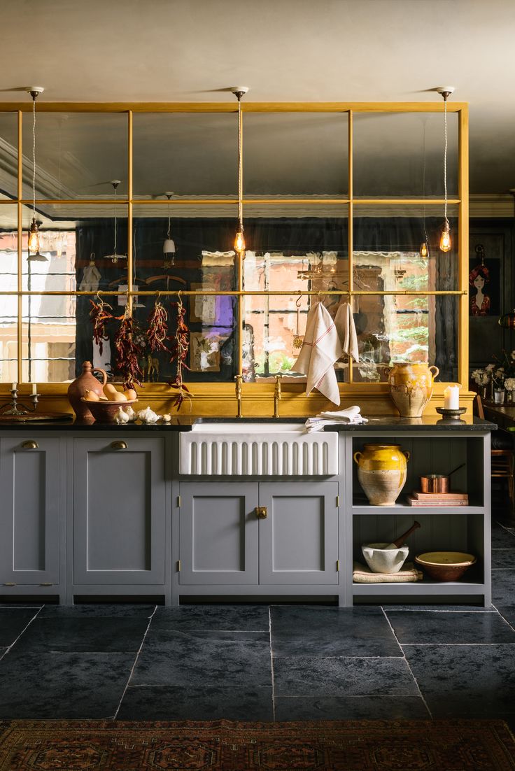 a kitchen with gray cabinets and yellow accents on the counter top, along with other items