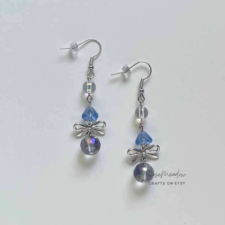 "Handmade Beaded Earrings ✿ Made with glass Czech beads, glass beads, and metal accents ✿ Silver, clear sky blue, iridescent clear, and iridescent deep grey ✿ The earrings are 2.25\" long Fish Hook Options ✿ The Titanium fish hook is hypoallergenic and ideal for sensitive skin ✿ The regular fish hook is made of nickel free metal, it is not hypoallergenic" Silver Glass Beaded Dangle Earrings, Silver Crystal Earrings For Jewelry Making, Adjustable Silver Glass Beaded Earrings, Silver Glass Drop Crystal Earrings, Silver Dangling Beads Glass Earrings, Silver Beaded Earrings With Round Glass Beads, Silver Glass Earrings With Dangling Beads, Silver Earrings With Dangling Glass Beads, Stolen Image