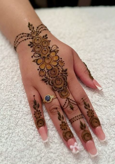 a woman's hand with henna tattoos on it