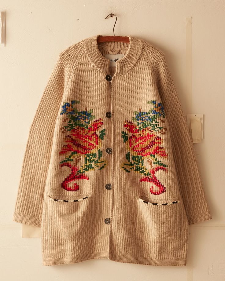 This jacket is inspired by a crochet blanket, circa 1850s-1870s. It features a faithful reproduction of the original motif reinterpreted as a knit with hand-embroidered details.  Elongated fit Four button closure  Two front pockets 100% wool   Made in Peru Dry clean only View all knitwear All wear, mending, and idiosyn Beige Cardigan With Floral Embroidery For Fall, Beige Floral Embroidered Cardigan For Fall, Beige Winter Cardigan With Floral Embroidery, Beige Floral Embroidered Winter Cardigan, Embroidered Wool Outerwear For Fall, Winter Floral Embroidered Knit Cardigan, Spring Wool Outerwear With Embroidery, Spring Wool Sweater With Embroidery, Spring Wool Embroidered Sweater