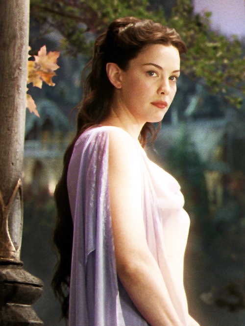 a woman in a purple dress standing next to a wooden pole and looking off into the distance