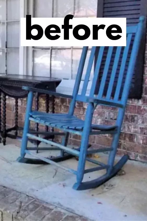 a blue rocking chair sitting on top of a sidewalk next to a table and window