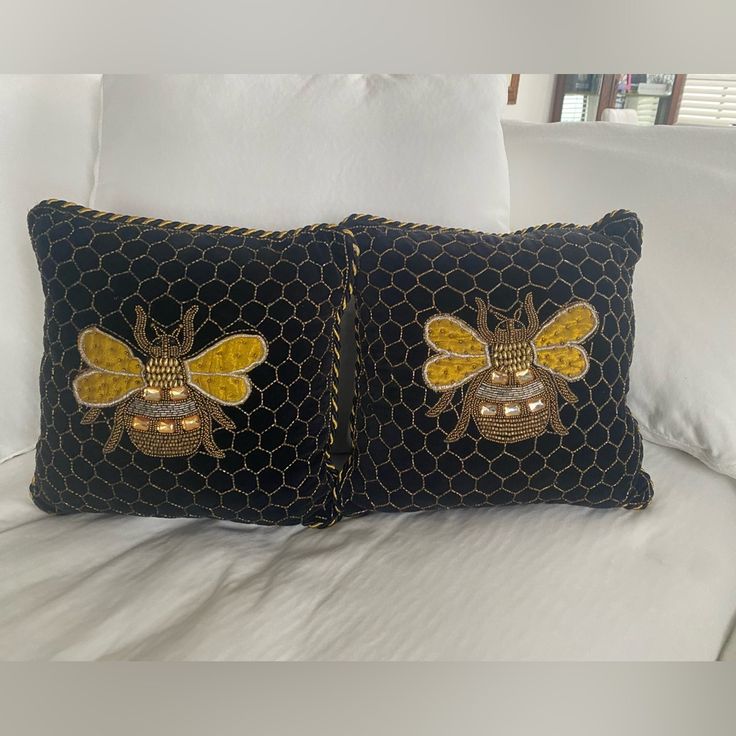 two black and yellow pillows with bees on them