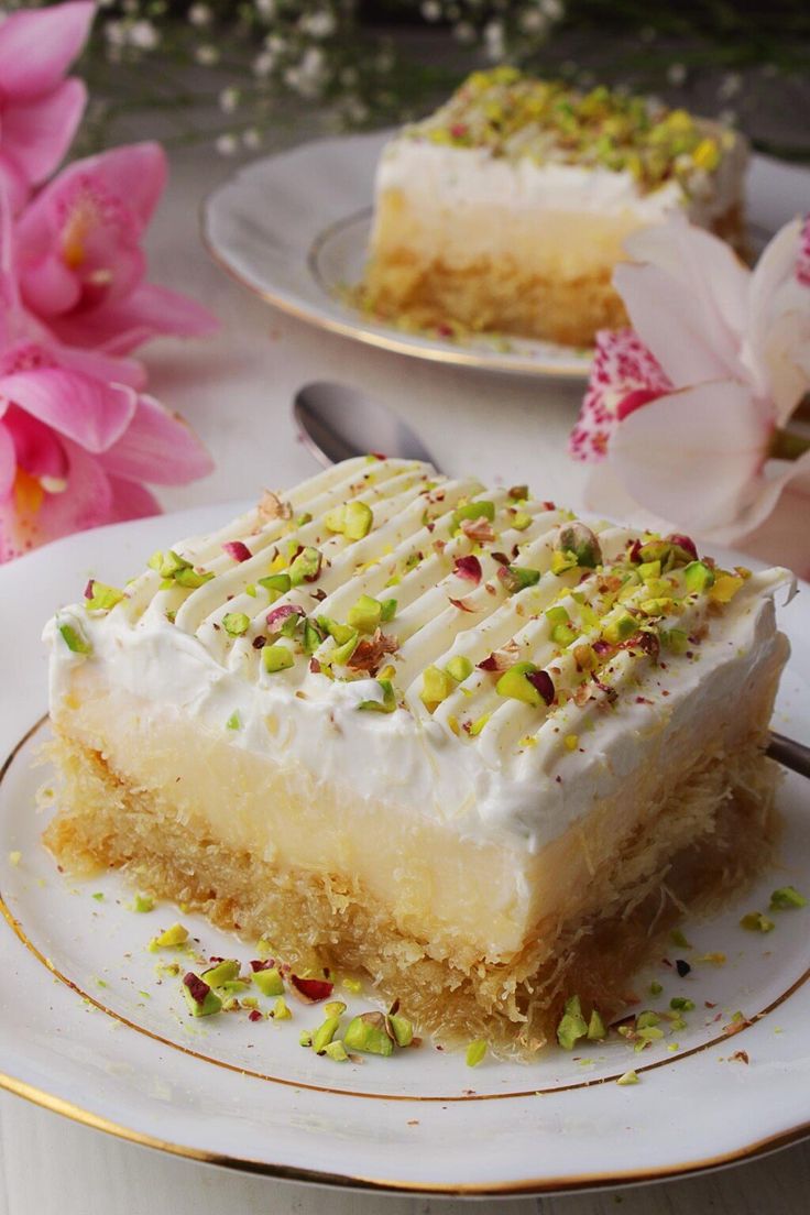 a piece of cake sitting on top of a white plate next to a pink flower