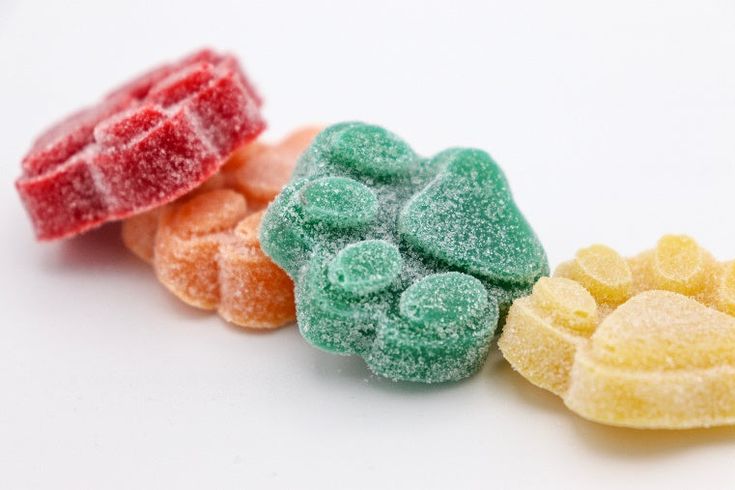 four different colored candies on a white background