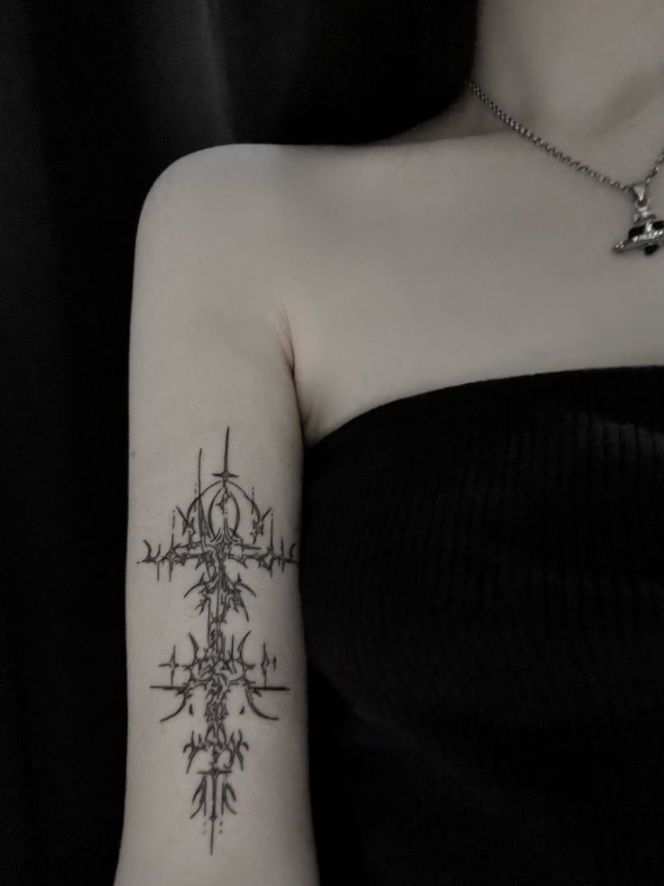 a woman's arm with a compass tattoo on the left side of her arm