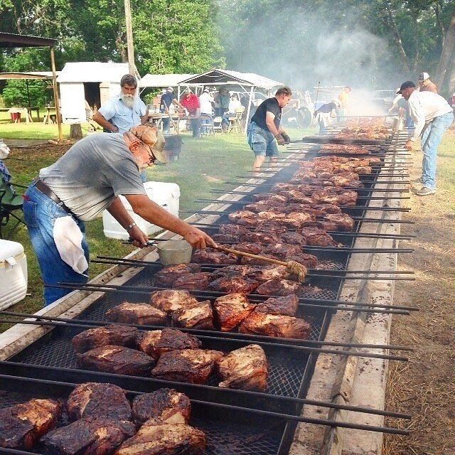 people grilling steaks on the grill at an outdoor event