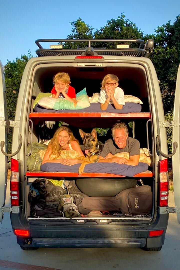 three people are sitting in the back of a van