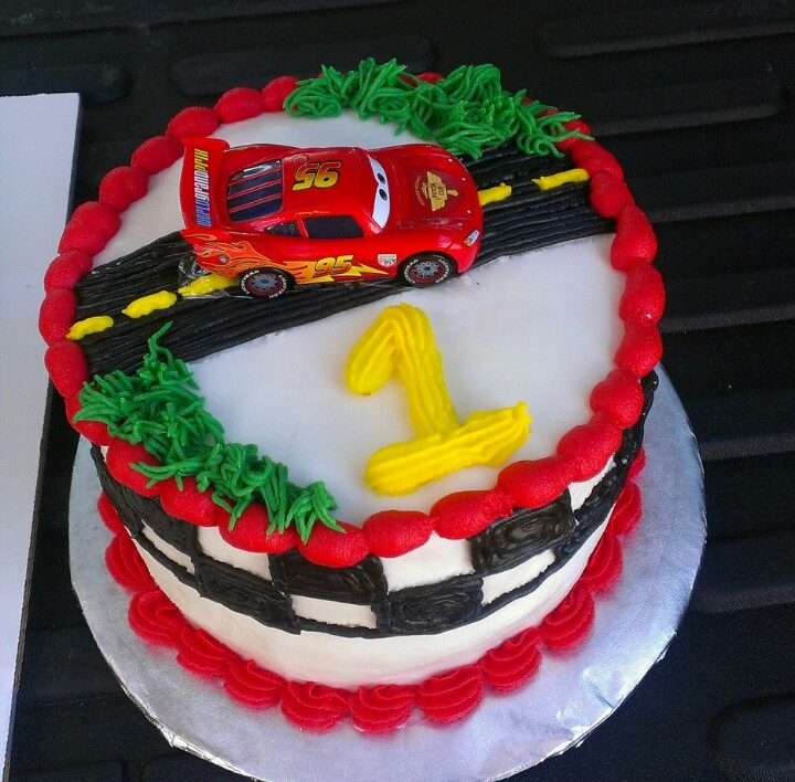 a birthday cake decorated with cars and trees