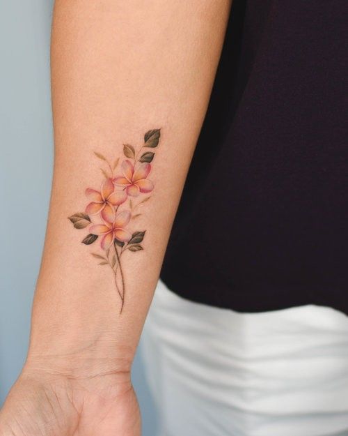 a woman's arm with a flower tattoo on the left side of her wrist