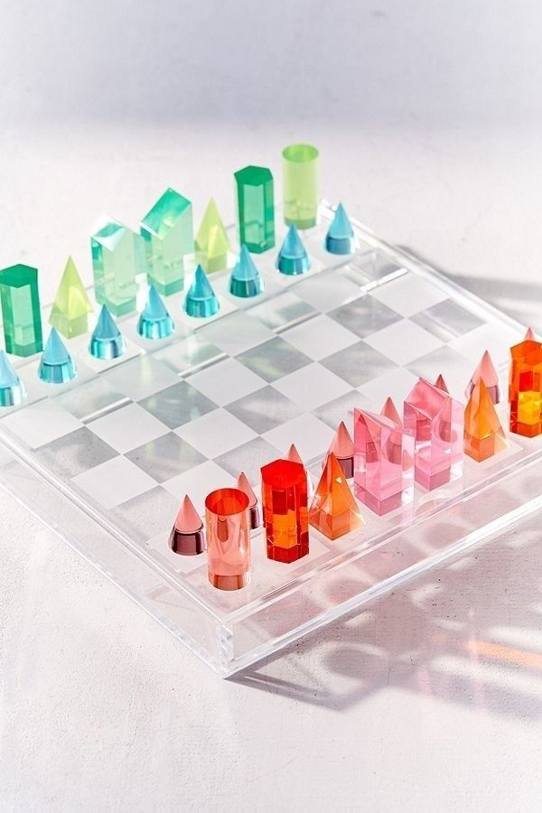 a glass chess board with colored pieces on it