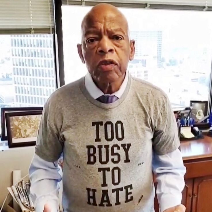 an old man wearing a shirt that says too busy to hate in front of him