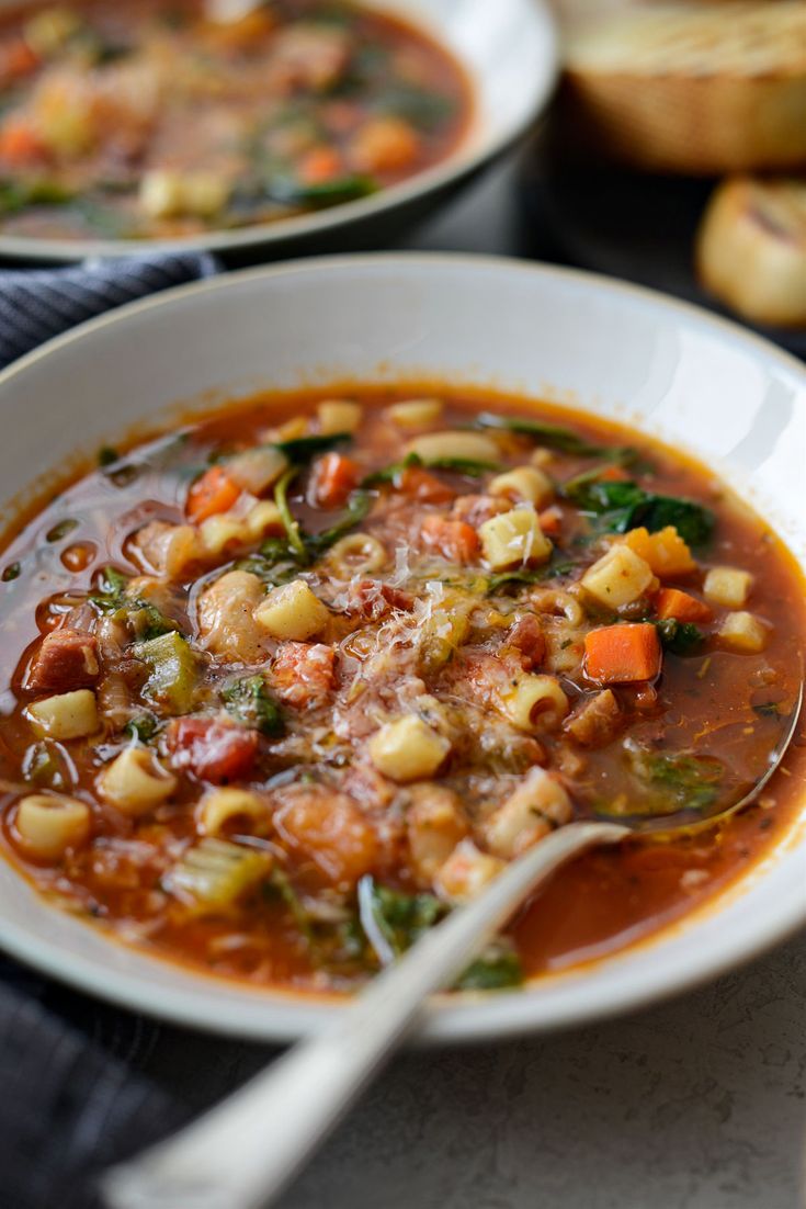 a white bowl filled with vegetable soup on top of a table