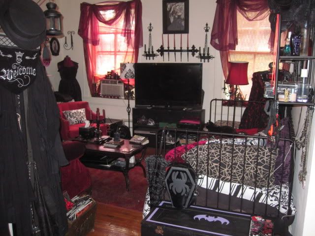 a living room filled with lots of furniture and halloween decorations on the wall above it