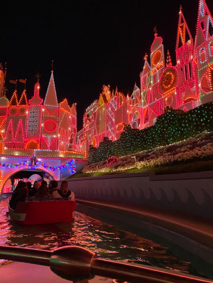 a boat is in the water with christmas lights on it's walls and buildings