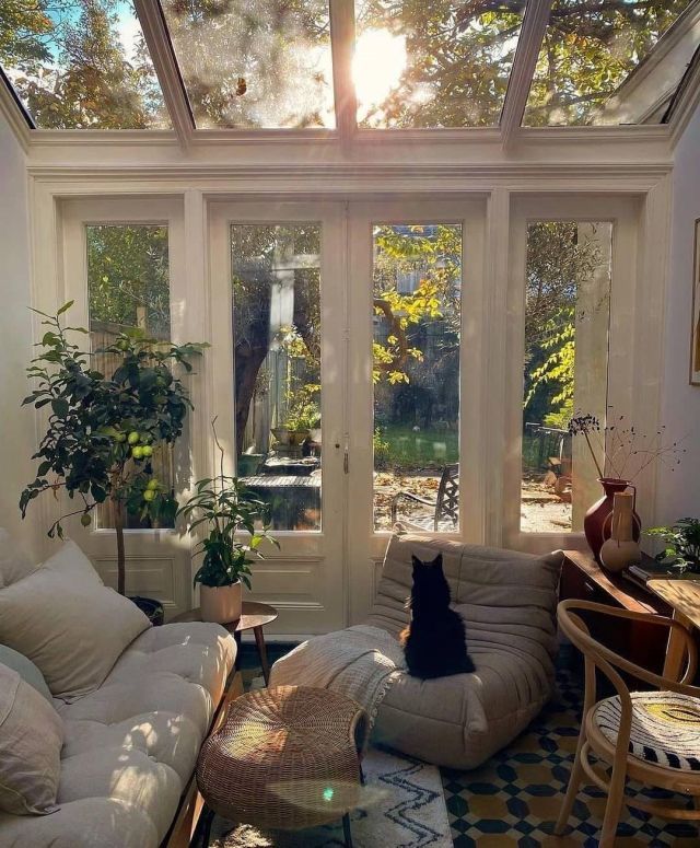 the sun shines through the glass roof in this living room