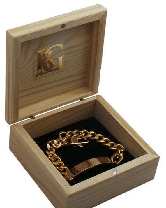 an open wooden box with a gold chain in it