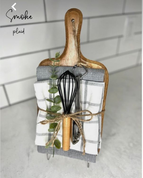 a kitchen utensil holder with a whisk and green leaves on it