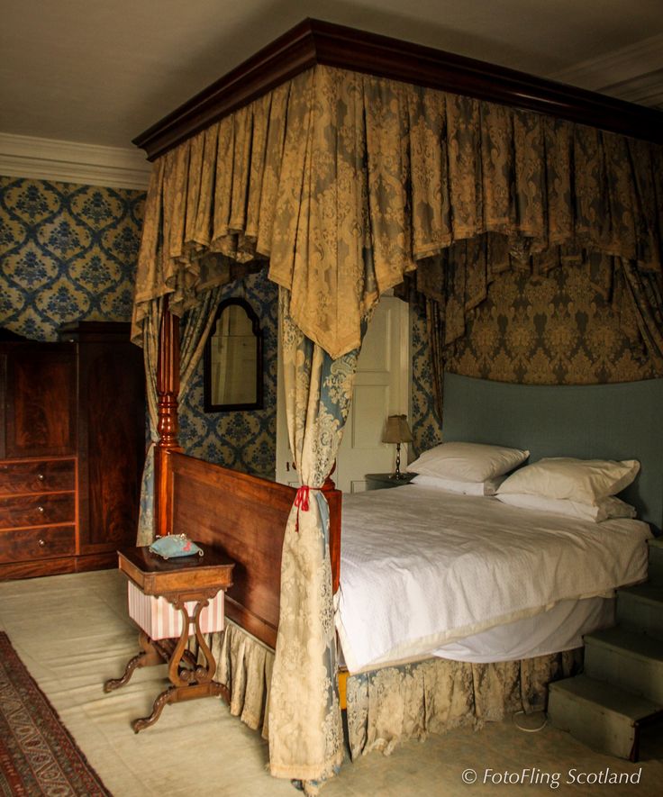 a four poster bed sitting in a bedroom next to a dresser