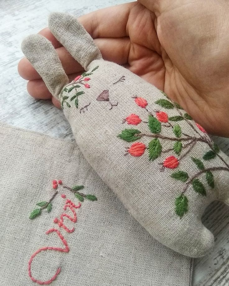 someone is holding a hand made doll with flowers on it's head and the word love written in red