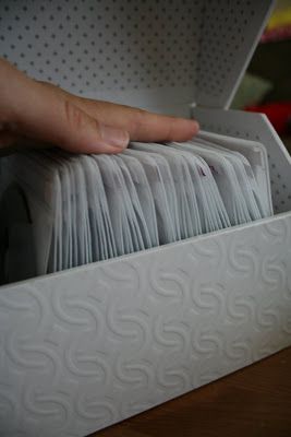 a hand is reaching into a white box filled with cards