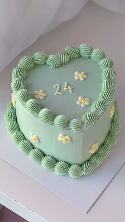 a heart shaped cake with the number twenty four on it's side and flowers in the middle