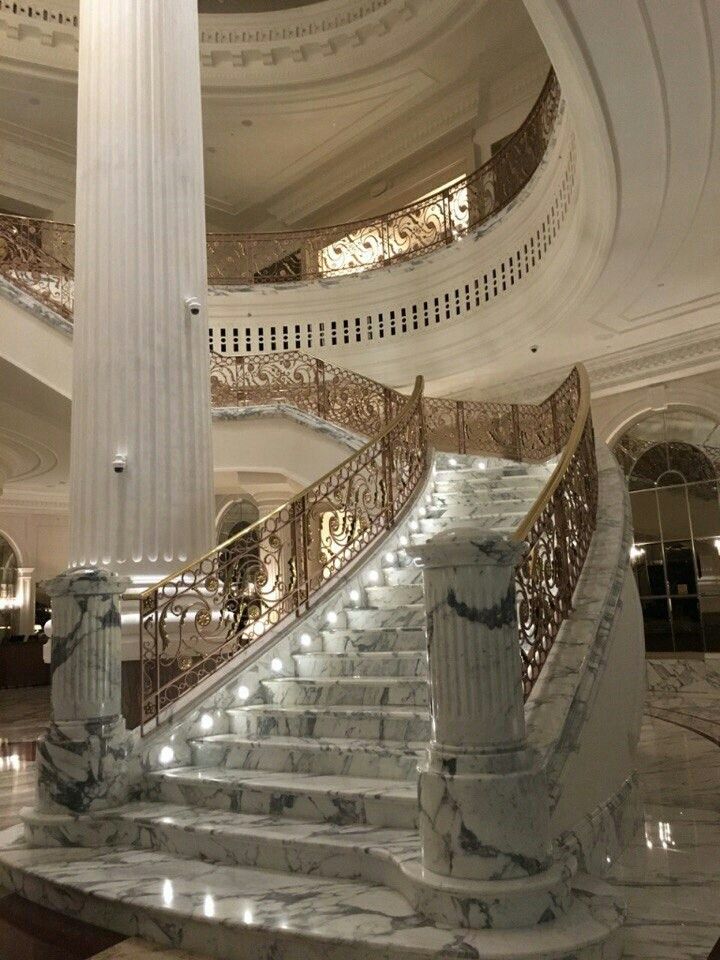 an ornate staircase with marble steps in a large building