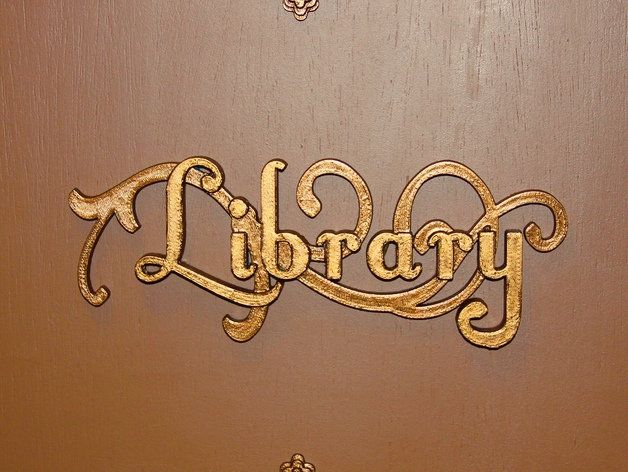 the word library written in cursive gold on a brown door