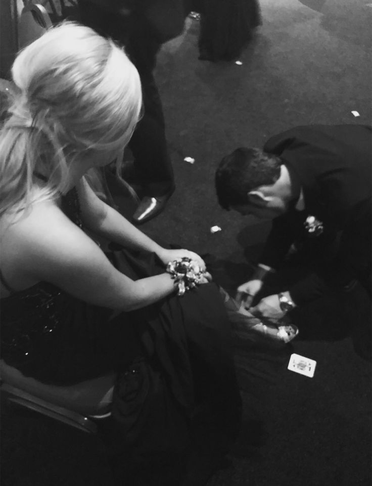 a man kneeling down next to a woman on the floor with confetti in her hand