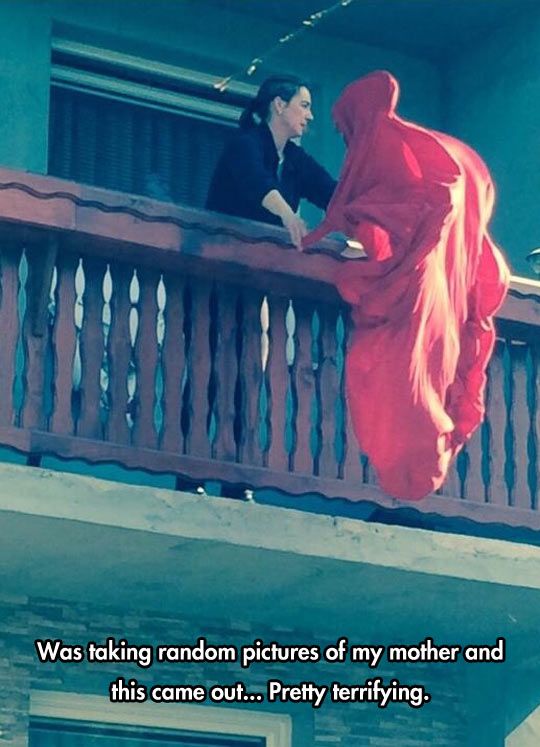 a woman in a red dress standing on a balcony