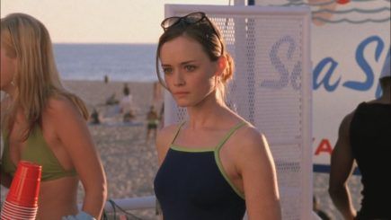 two women standing next to each other at the beach