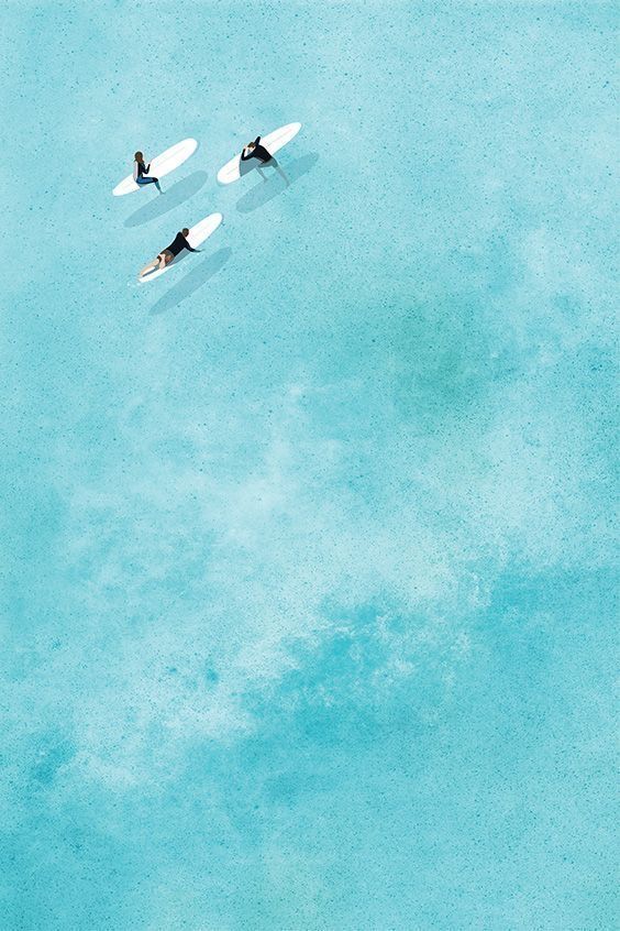 three people on surfboards floating in the water