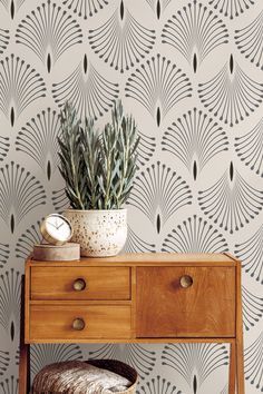 a wooden table with a plant on top of it next to a wallpaper design